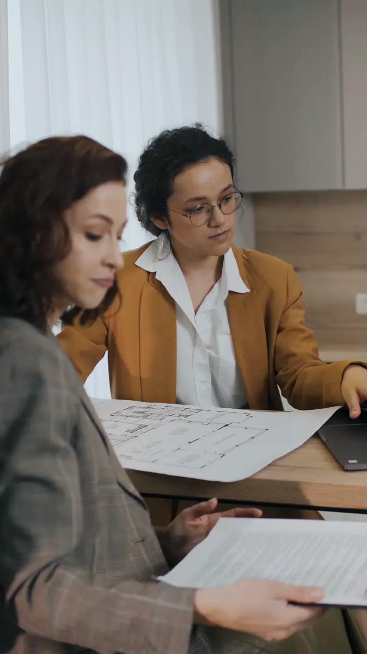 Corredoras revisando el plano de una propiedad